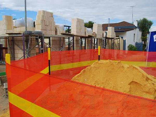 Star pickets and orange shade cloth are used to circle soils in the construction site.