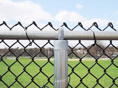 A black chain link fence with a thick horizontal rail and a vertical post.