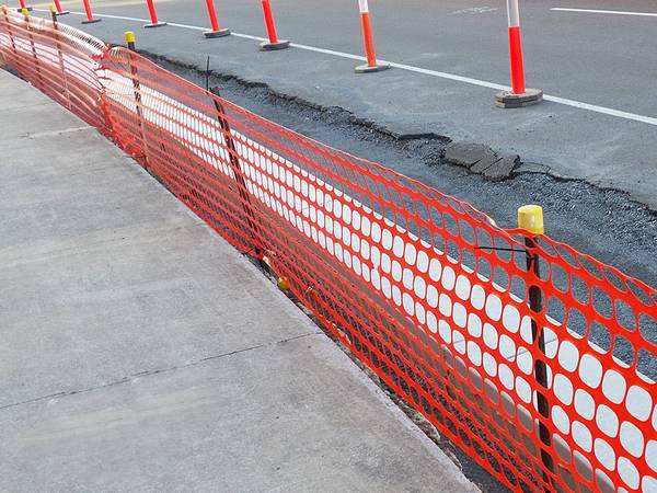 Star pickets are used to support the orange safety barriers and are installed along the road under construction.